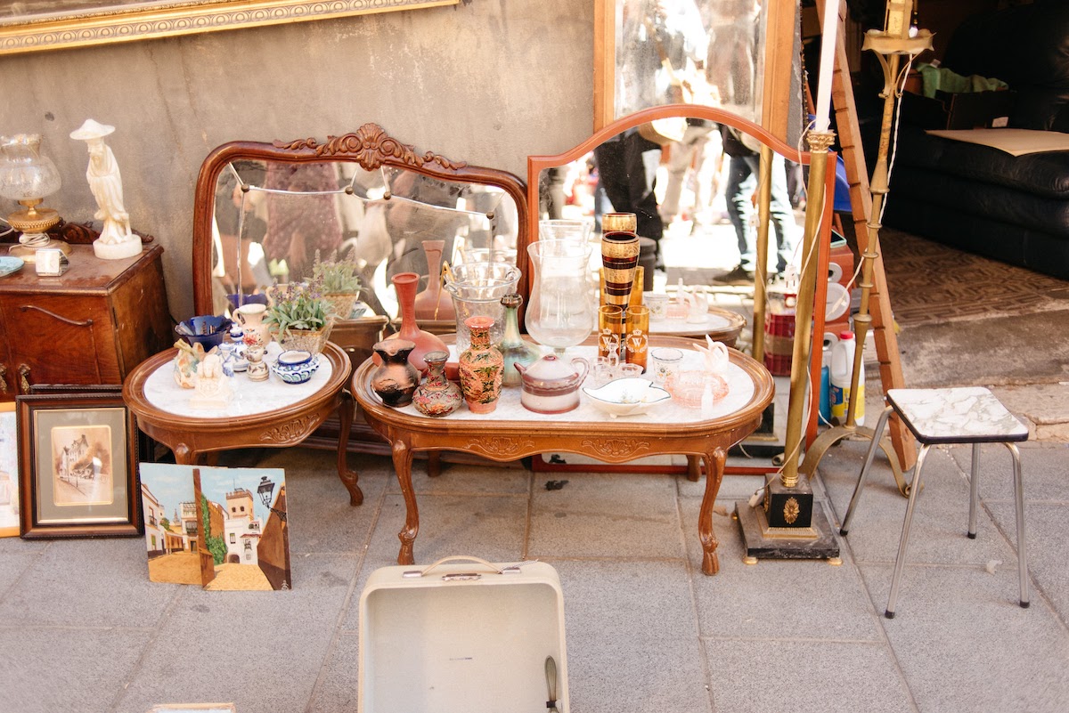 Antigüedades restauradas, incluidos muebles de madera y espejos, a la venta en un mercado de pulgas.