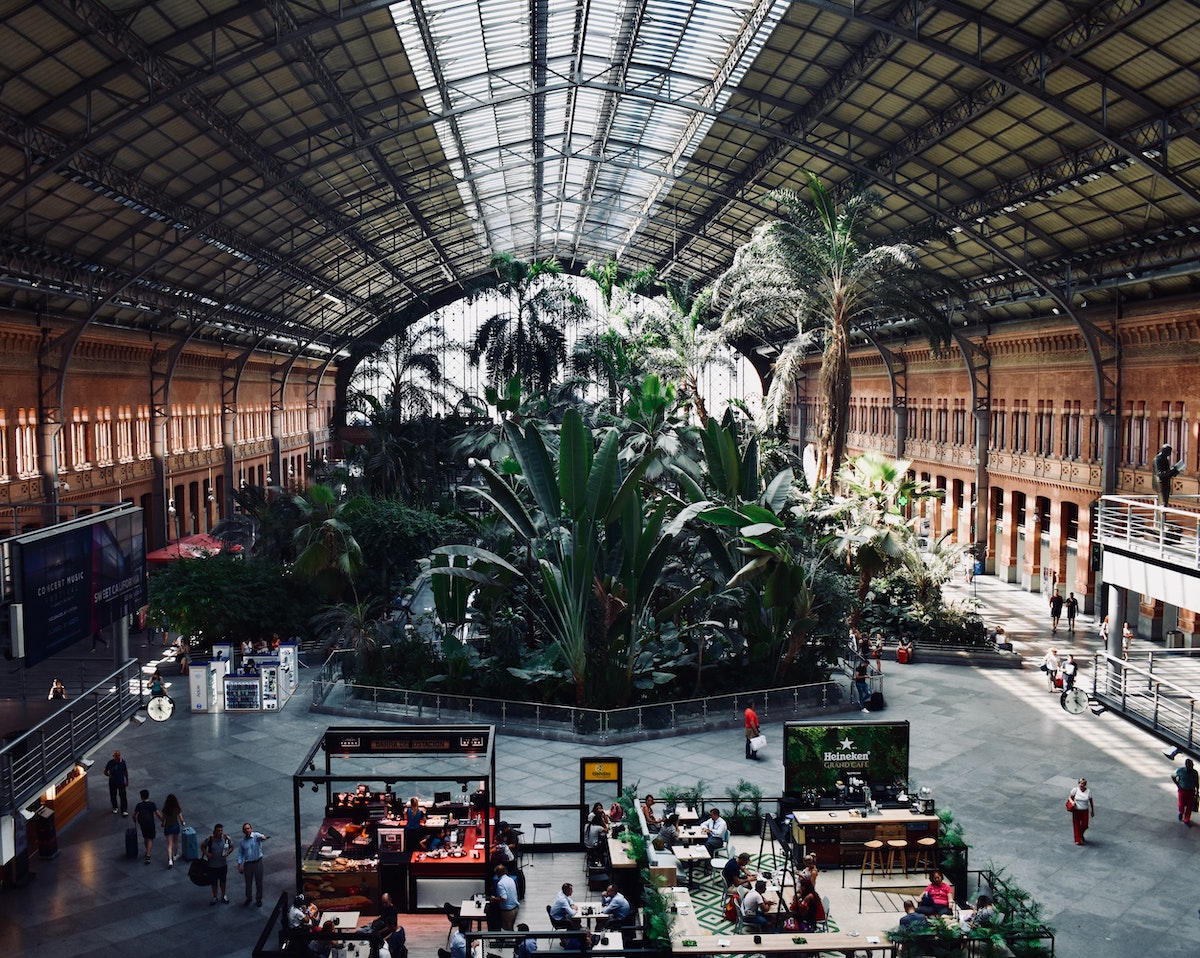 Interior de una estación de tren con un gran jardín tropical